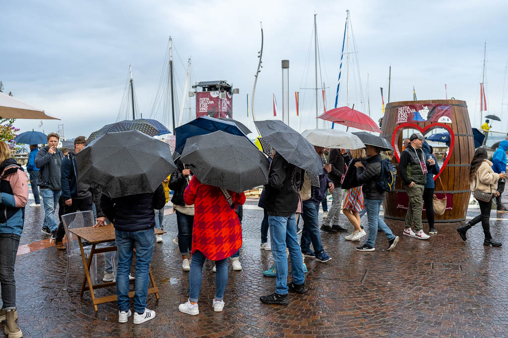 Besucher mit Regenschirmen auf dem Weinfest von Bardolino