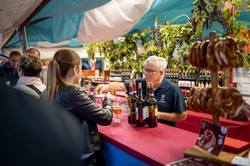 Eine Frau bestellt ein Glas Wein auf dem Weinfest in Bardolino