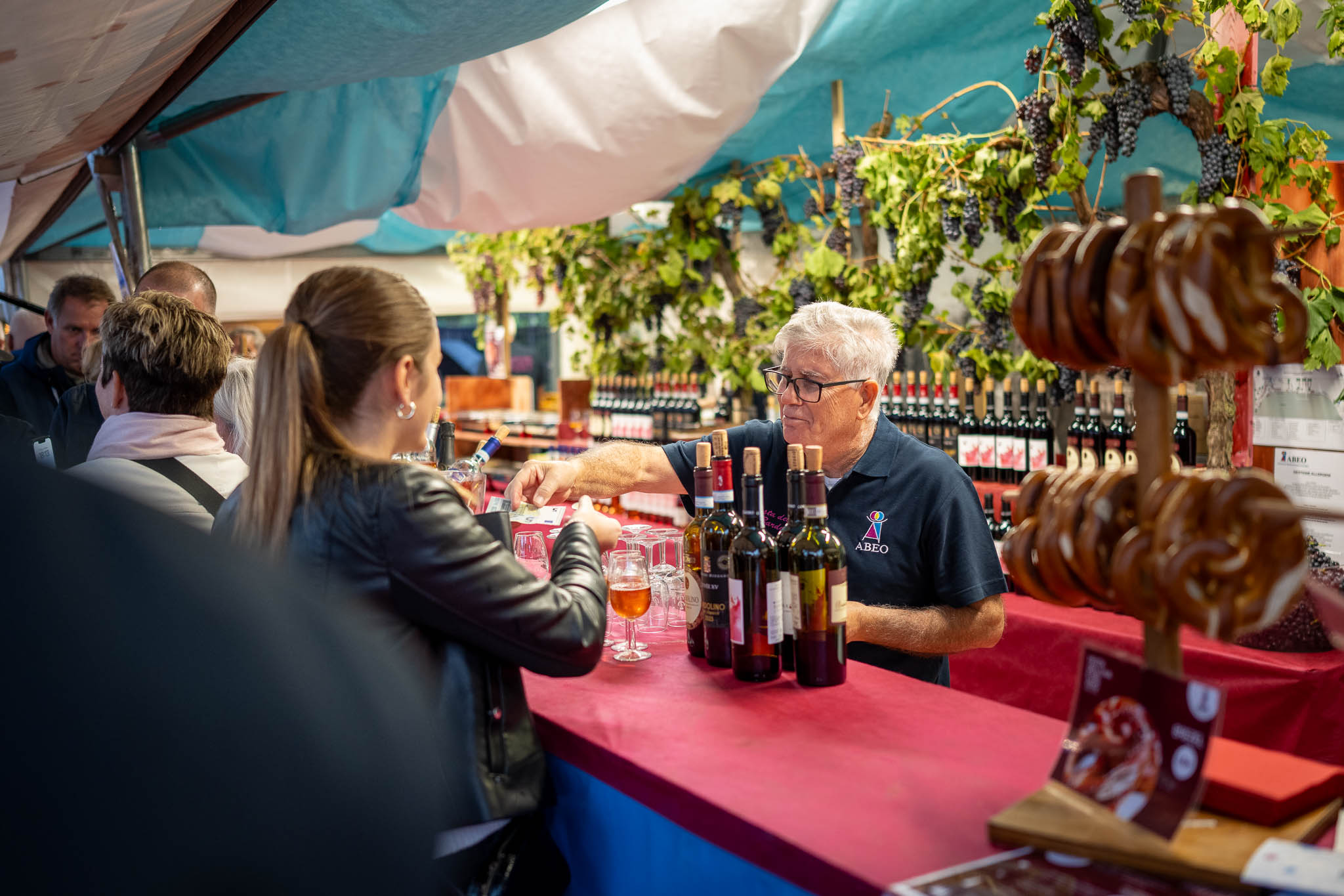 Eine Frau bestellt ein Glas Wein auf dem Weinfest in Bardolino