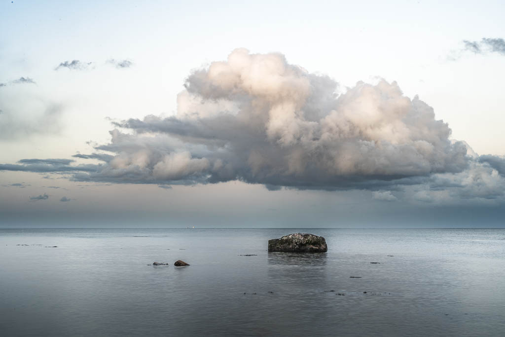 Dramatische Wolken über einem Findling am Südstrand