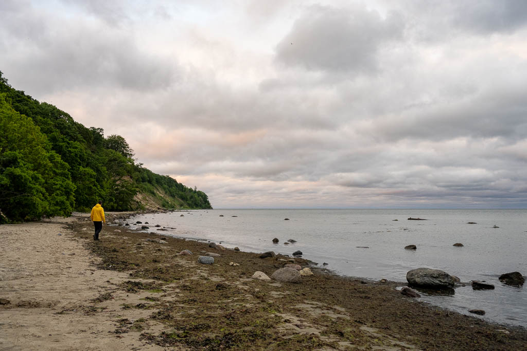 Ein Fotograf in gelber Jacke läuft am Südstrand entlang